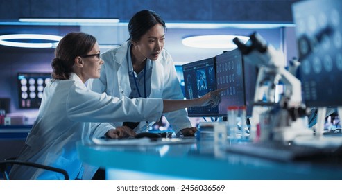 Medical Hospital Research Laboratory: Caucasian And Asian Female Scientists Talking And Using Desktop Computer With CT Scans Of Human Brain. Surgeon And Neurologist Discussing Brain Damage Treatment. - Powered by Shutterstock