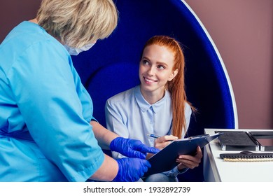 medical insurance concept.redhead ginger pregnant woman patient with a gynecologist during the consultation in the gynecological office,signing a document.sex education