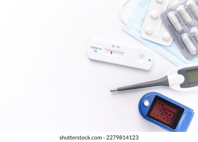 Medical kit for the prevention and treatment of coronavirus. Mask, test, pulse oximeter and medication on a white background.