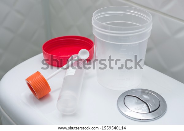 Medical kit for the sampling\
of feces and empty urine sample cup. Medical laboratory tests,\
concept.