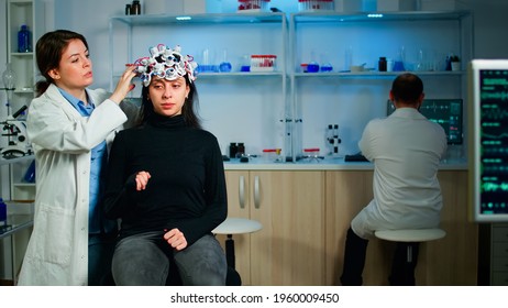 Medical Lab Technician Adjusting Eeg Headset Monitoring Brain Functions, Descovering Diagnosis Of Disease. Team Of Scientists Researchers Working Late Night In Neurology Clinic For Woman Health