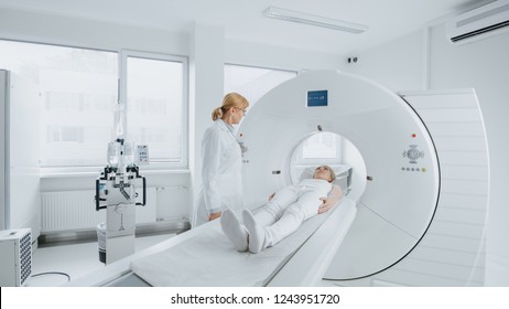 In Medical Laboratory Female Radiologist Controls MRI or CT Scan with Female Patient Undergoing Procedure. High-Tech Modern Medical Equipment.