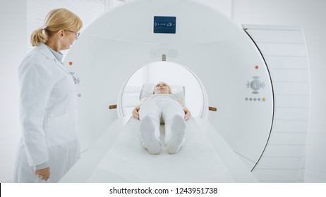 In Medical Laboratory Female Radiologist Controls MRI Or CT Or PET Scan With Female Patient Undergoing Procedure. Doctor Conducts Emergency Scanning With Advanced Medical Technologies.