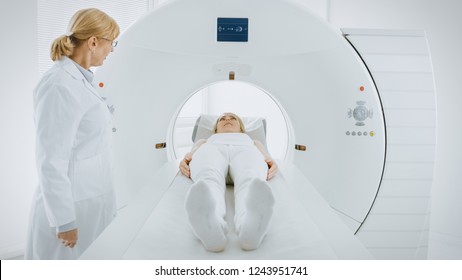 In Medical Laboratory Female Radiologist Controls MRI Or CT Or PET Scan With Female Patient Undergoing Procedure. Doctor Conducts Emergency Scanning With Advanced Medical Technologies.