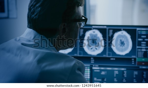 In Medical\
Laboratory Patient Undergoes MRI or CT Scan Process under\
Supervision of Radiologist in Control Room, He Watches Procedure\
and Monitors Brain Activity\
Results.