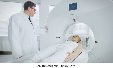 In Medical Laboratory Radiologist Controls MRI Or CT Or PET Scan With Female Patient Undergoing Procedure. Professional Doctor Conducts Emergency Checkup Procedure With Advanced Medical Technologies.