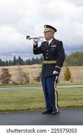 MEDICAL LAKE, WA. USA - OCTOBER 15, 2014. A Man Plays Taps On His Bugle At A Veterans Funeral At Medical Lake Veterans Memorial In Washington.