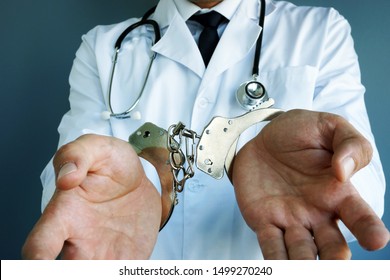 Medical Malpractice Concept. Doctor With Handcuffs On Hands.