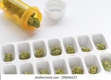 Medical marijuana buds arranged in a prescription pill bottle and a weekly pill box