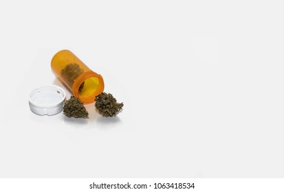 Medical Marijuana In An Orange Pill Container To Represent Cannabis Available Through A Doctor's Prescription. The Medical Cannabis Is For Medical Use Only  For Health Care Patients With A Card. 