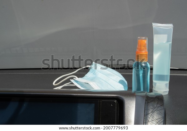 Medical mask, alcohol sanitizer hand gel and hand\
sanitizer spray placed on console inside the car, preparation of\
portable disinfectant alcohol spray, prevention of Covid-19\
concept. New Normal\
life.