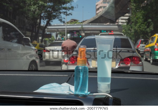 Medical mask, alcohol sanitizer hand gel and hand
sanitizer spray placed on console inside the car, preparation of
portable disinfectant alcohol spray, prevention of Covid-19
concept. New Normal
life.
