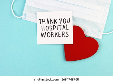 Medical Mask, Healthy Red Heart And The Inscription Thank You To Hospital Workers On A Blue Background. Concept Of Gratitude To Medical Workers During The Coronavirus Pandemic