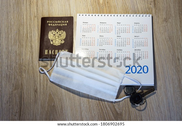medical mask and keys, medical mask and
passport on the table, white medical mask and calendar for 2020
(January, February, May,
December)