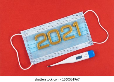 Medical Mask And Numbers 2021 On A Red Background. Surgical Protective Mask. Respiratory Bandage Face And Thermometer. Medical Christmas. 100 Days Masking Challenge. Coronovirus New Year