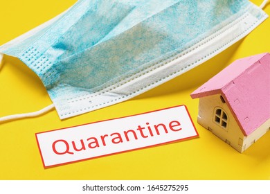 Medical Mask, Toy House And A Sheet Of Paper With The Inscription. Quarantine Concept