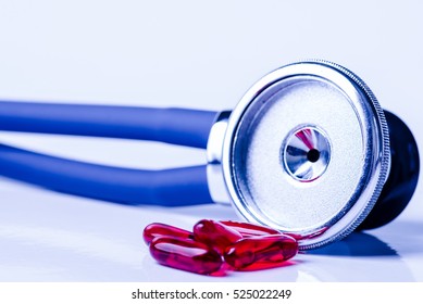 Medical, medicine stethoscope and pills on blue background. Health care or illness. Tablet or drug in hospital or pharmacy. Cardiology heart treatment. Medication prescription