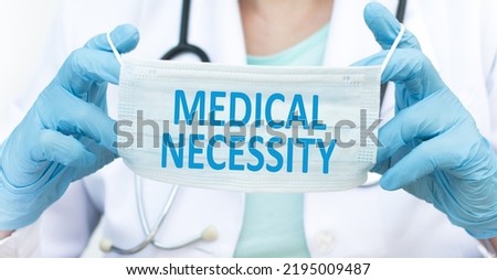 Medical necessity text on a protective mask in the hands of a doctor, a medical concept [[stock_photo]] © 