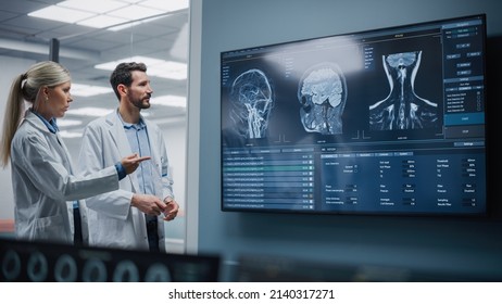 Medical Neuroscience Hospital Lab Meeting: Diverse Team Of Neurosurgeon And Neurologist Analyze TV Screen Showing MRI Scan With Brain Images, Talk About Sick Patient Treatment Method, New Drugs Cure