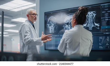 Medical Neuroscience Hospital Lab Meeting: Diverse Team Of Neurosurgeon And Neurologist Analyze TV Screen Showing MRI Scan With Brain Images, Talk About Sick Patient Treatment Method, New Drugs Cure