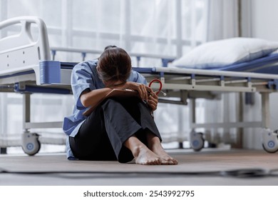 Medical nurse is on bed in hospital sitting down a the hospital corridor in frustration and grief after failure and patient body condition - Powered by Shutterstock