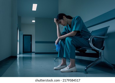 Medical nurse is sitting down a the hospital corridor in frustration and grief after failure and patient body condition - Powered by Shutterstock