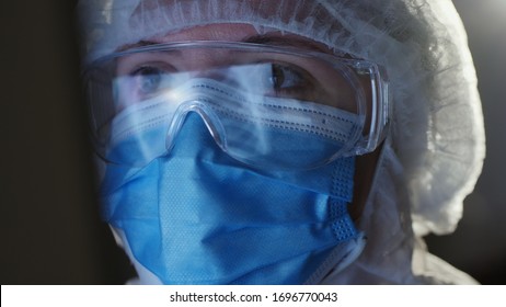 A medical officer in a protective uniform is looking at the computer screen, close-up face. Doctors work during the pandemic covid-19 - Powered by Shutterstock