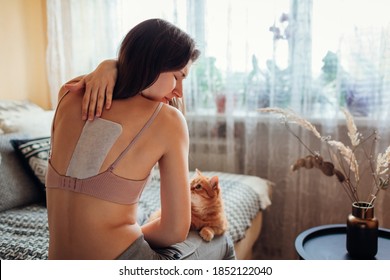 Medical Patch For Back Pain Relief. Woman Appied Plaster On Shoulder Blade At Home Suffering From Spine Ache