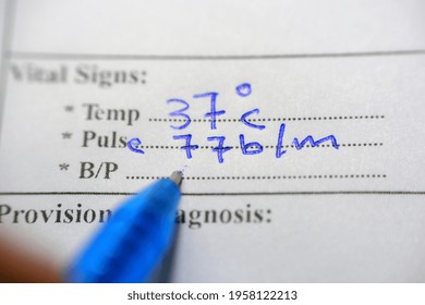 A Medical Personnel Writing The Vital Data (body Temperature, Pulse And Blood Pressure) Of A Patient Following Up His Case In A Medical Chart