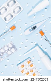 Medical, pharmacy remedies for health, prevent, teraphy disease - home medicine chest - white sprays, pills, 36,6 thermometer, silver antibiotic, orange syringe pattern on blue, top view, vertical. - Shutterstock ID 2247502383