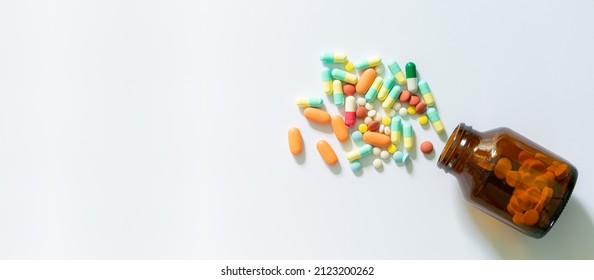 
Medical: Pills and bottle, aerial view,white pills and pill bottles,Medicine and a small bottle,Still life with pile of white pills or tablets and glass bottle or glass and space for text.