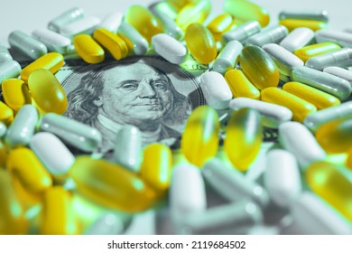 Medical Pills Lying On Top Of Hundreds Of US Dollar Bill. Big Pharma Conspiracy Theory. Pharmacy And Healthcare Are Very Expensive