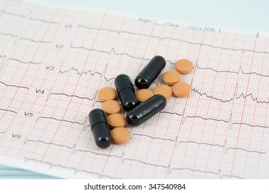 Medical Pills On A ECG. Pills On A ECG Strip. Hearth Disease And A Cure.