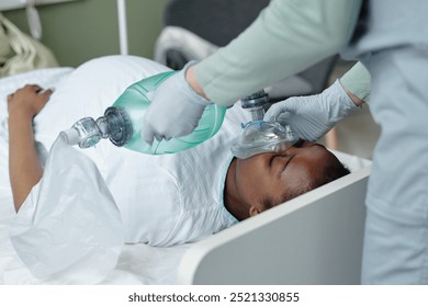 Medical professional giving emergency assistance with oxygen mask in hospital room demonstrating essential care during critical condition demonstrating urgency and medical aid procedure - Powered by Shutterstock