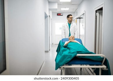 Medical professional pushing patient on gurney through hospital corridor. Patient hospital bed moved by medical staff to operating room. Male healthcare worker moving patient in another hospital room. - Powered by Shutterstock