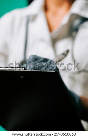Medical professional taking notes while wearing gloves in a healthcare setting