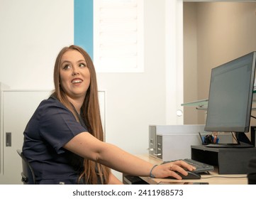 Medical Professional at Workstation Engaging with Off-Screen Colleague - Powered by Shutterstock