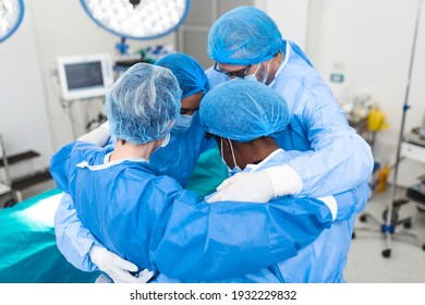 Medical professionals embracing each other in ICU. Doctors and nurses are in protective coveralls after successful treatment. They are at hospital during COVID-19. - Powered by Shutterstock