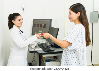 Medical Radiologist Smiling While Giving A Usb Flash Drive With Her Mammogram Results And Diagnosis To A Happy Young Woman 