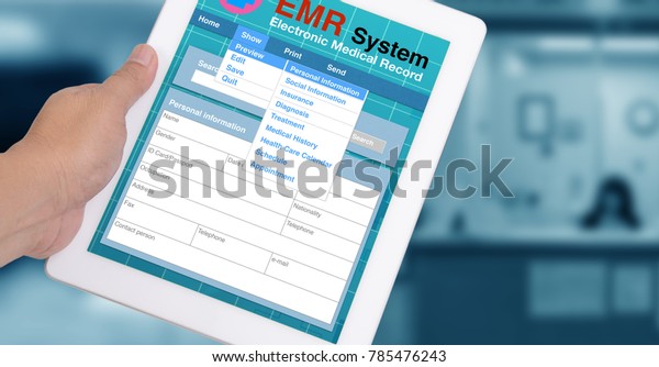 Medical record system show on tablet in\
someone hand with blue\
background.