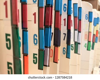 Medical Records Of Patients In Numbered And Color Coded Folders Are Organized And Arranged Numerically And Sequentially In Open Shelves Of A Clinic.