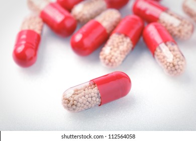 medical red pills close up on white table