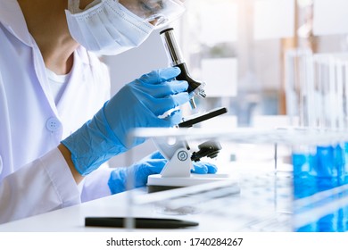 Medical Research Asian Scientist Working With Microscope Doing Research Making Scientific Experiment, Works In A Bright Modern Laboratory