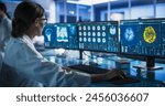 Medical Research Center Laboratory: Caucasian Female Neurologist Using Desktop Computer With MRI And PET Scans Of a Brain. Professional Doctor Looking For Areas of Patient