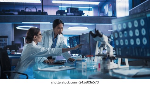 Medical Research Center Laboratory: Caucasian And Asian Female Scientists Talking And Using Desktop Computer With MRI Scans Of Human Brain. Surgeon And Neurologist Discussing Brain Damage Treatment. - Powered by Shutterstock