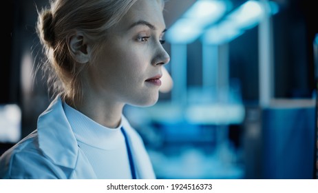 Medical Research Laboratory: Close-up Side View Portrait of Female Scientist Working on Computer. Advanced Scientific Lab for Medicine, Biotechnology, Vaccine Development. Dark Blue Shot - Powered by Shutterstock