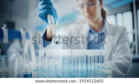 Medical Research Laboratory: Portrait of a Beautiful Female Scientist in Goggles Using Micro Pipette for Test Analysis. Advanced Scientific Lab for Medicine, Biotechnology, Microbiology Development