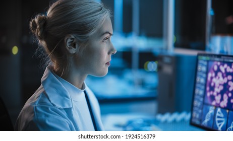 Medical Research Laboratory: Portrait Of Female Scientist Working On Computer, Analysing DNA, Virus. Advanced Scientific Lab For Medicine, Biotechnology, Vaccine Development. Dark Close-up Shot