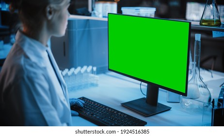 Medical Research Laboratory: Portrait Of Female Scientist Working On Computer With Green Chroma Key Screen. Advanced Scientific Lab For Medicine, Biotechnology, Vaccine Development. Dark Blue Shot