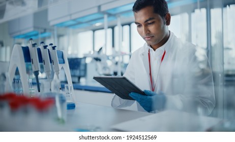 Medical Research Laboratory: Portrait Of A Handsome Male Scientist Using Digital Tablet Computer To Analyse Data. Advanced Scientific Lab For Medicine, Biotechnology, Microbiology Development